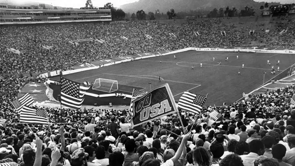 fans watching soccer game in black and white